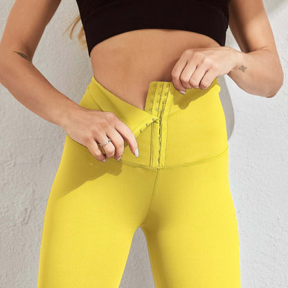 Woman adjusting seamless compression leggings in bright yellow for comfortable fit and style.