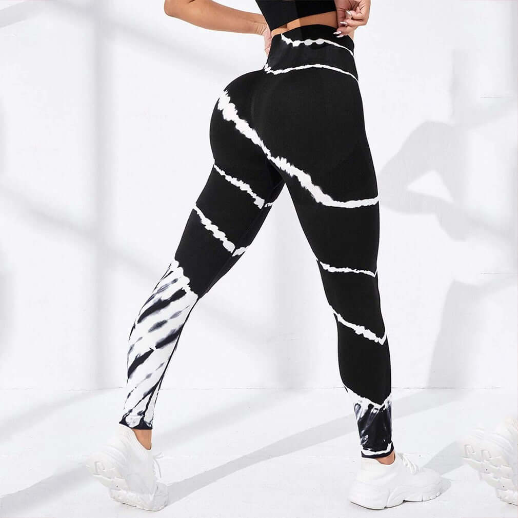 Black and white tie-dye compression workout pants for women, shown from the back in a fitness setting.