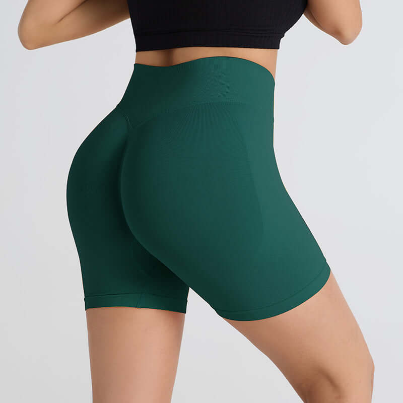 Woman wearing green booty-lifting sports shorts enhancing shape and comfort for workouts.