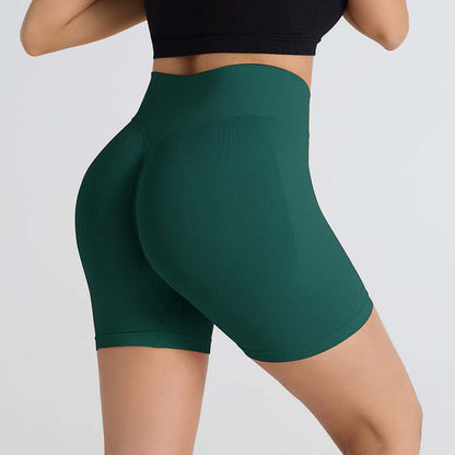 Woman wearing green booty-lifting sports shorts enhancing shape and comfort for workouts.