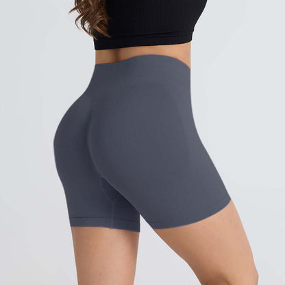 Woman wearing grey booty-lifting sports shorts, highlighting a comfortable and stylish fit for workouts and active lifestyle.