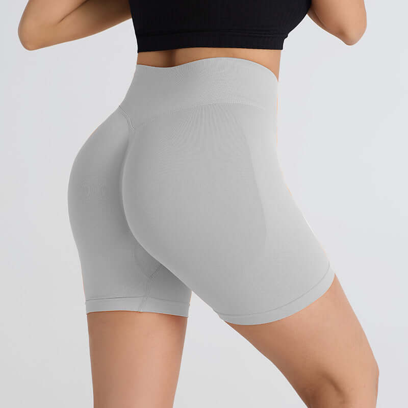 Woman wearing booty-lifting sports shorts in grey, showcasing a flattering fit and supportive design for workouts and casual wear.