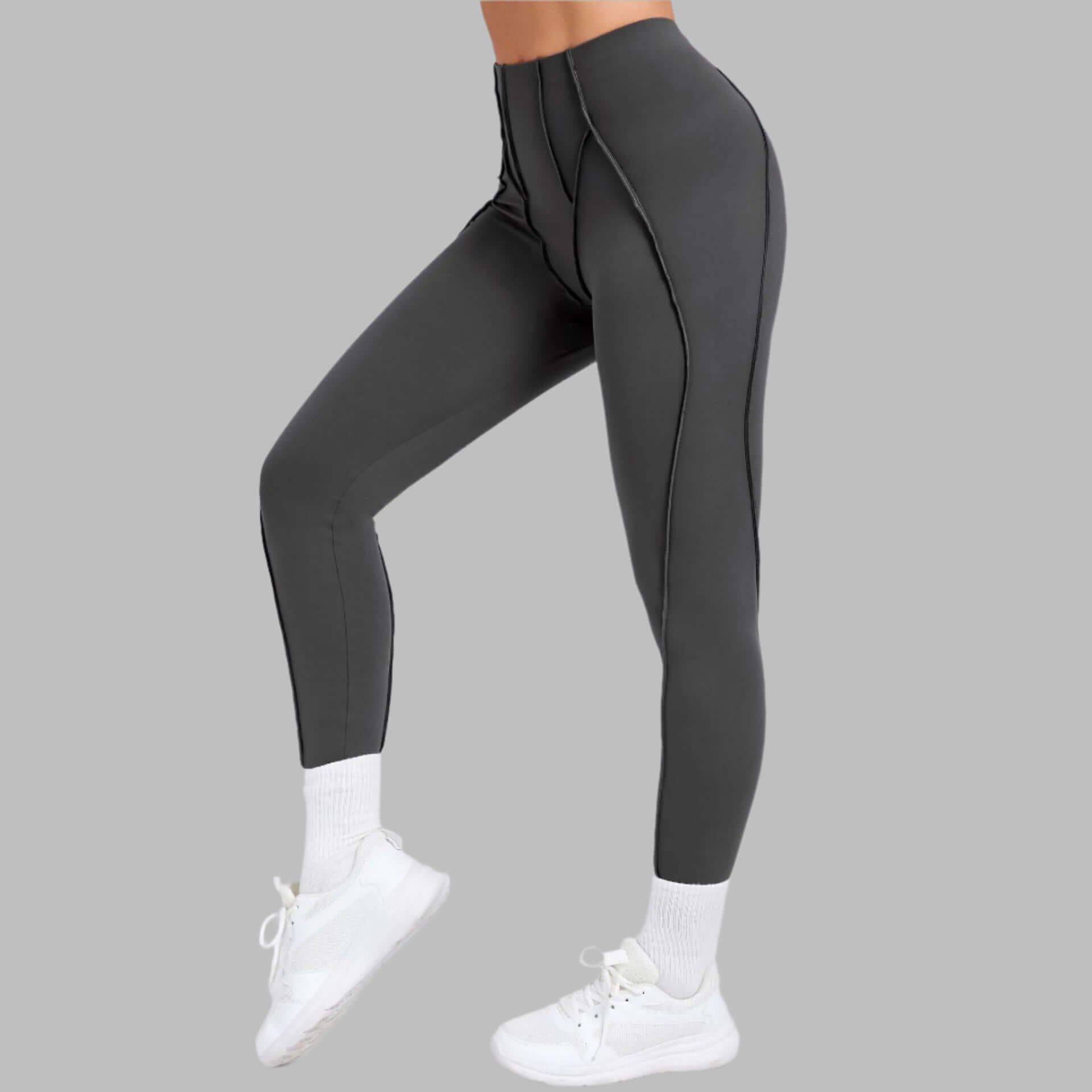 Grey compression gym leggings on model, side view, showcasing high waist and form-fitting design for active wear.