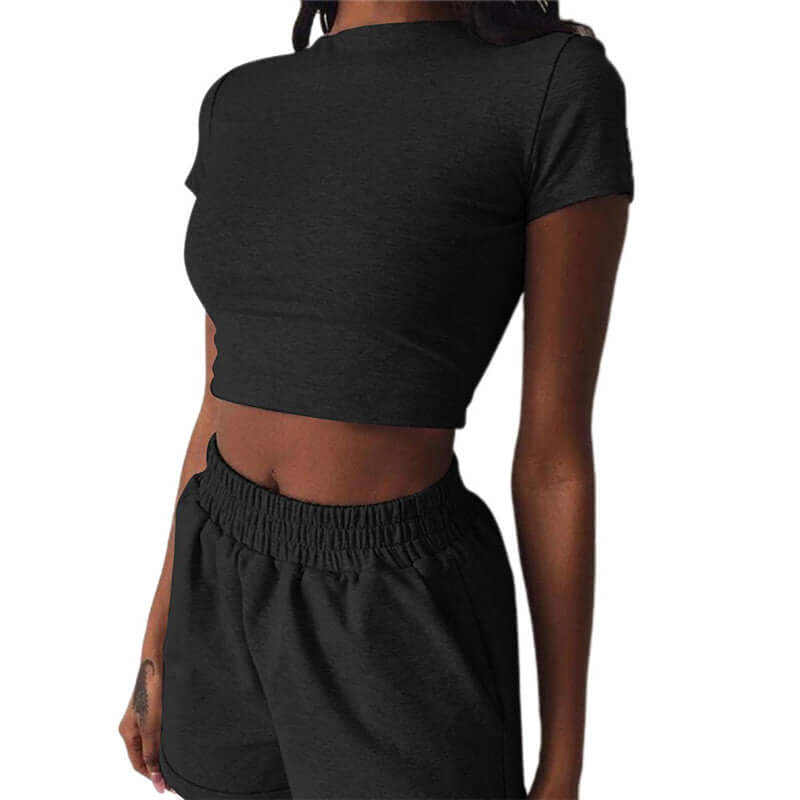 Woman wearing a black casual sports suit with a fitted cropped top and matching shorts, showcasing a comfortable and stylish athletic look.