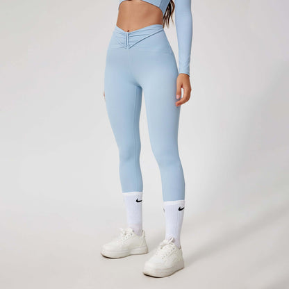 Woman wearing seamless shaping leggings in light blue, paired with white sneakers and socks, showcasing a sleek and comfortable fit.