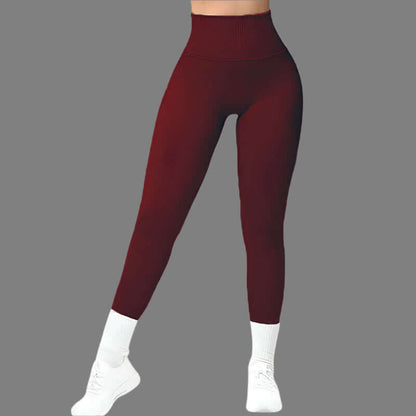 High-waisted seamless fitness leggings in maroon, showcasing a form-fitting design with white socks, perfect for workouts and athleisure fashion.