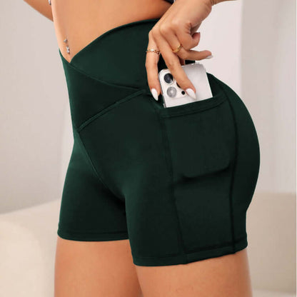 Dark green workout compression shorts with a side pocket holding a phone, showcasing a stylish and functional design.