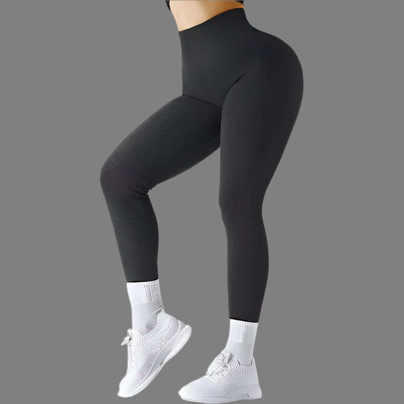 Black seamless fitness leggings worn by model with white sneakers, showcasing high-waisted design and stretchy fabric for workout.