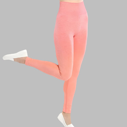 Woman wearing peach yoga leggings and top, performing dance pose.