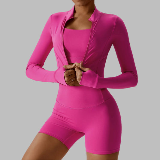 Woman wearing a vibrant pink outdoor skinny suit, featuring a fitted jacket and shorts, perfect for athletic and leisure activities.