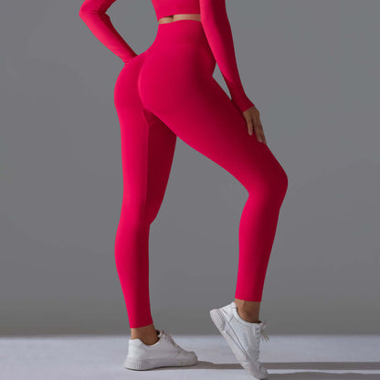 Woman wearing seamless high waist leggings in vibrant red, showcasing sleek design and fit with white sneakers on a neutral background.