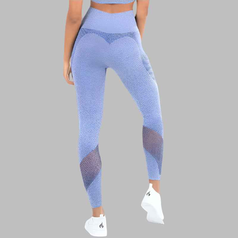 Woman wearing blue textured fitness leggings, back view, showcasing design and fit, with white sneakers against a gray background.