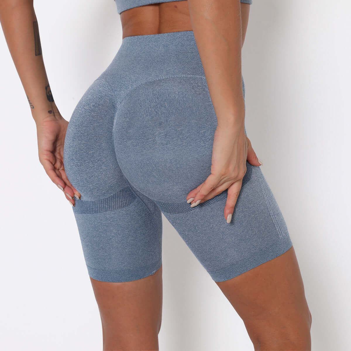 Back view of a person wearing high-waisted blue seamless athletic shorts for women, highlighting comfort and style.