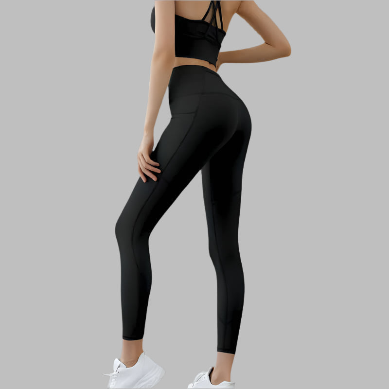 Black high waist pocket leggings shown from the side, paired with athletic top and white sneakers, highlighting fit and style.