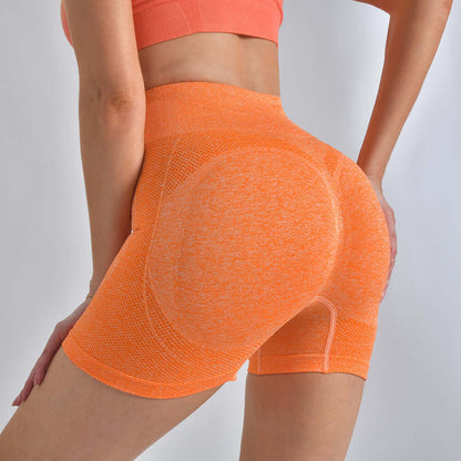 Woman wearing orange high-waist striped yoga shorts providing hip-lifting support, ideal for running and fitness, highlighting back view.