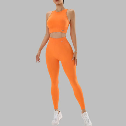 Bright orange 2-piece activewear set featuring a sleeveless crop top and high-waist leggings, ideal for workouts, with white sneakers.