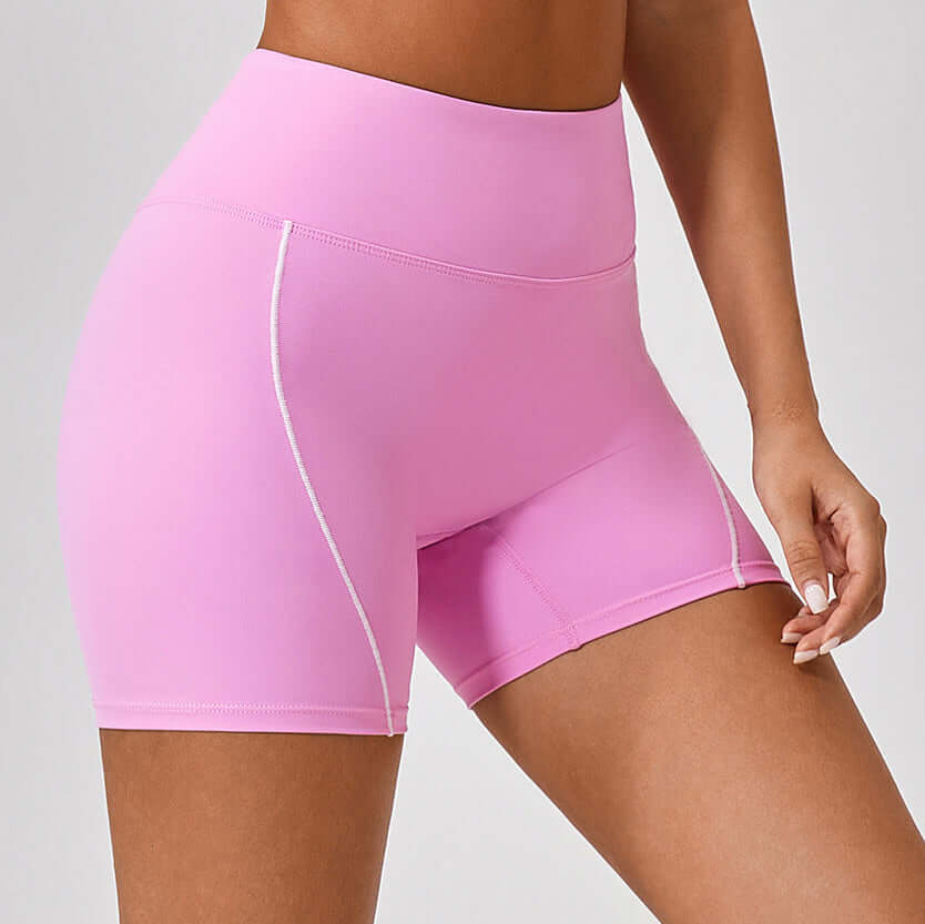 Pink high-waist fitness shorts for women with white seams, designed for comfort and performance. Ideal for gym, yoga, and summer workouts.