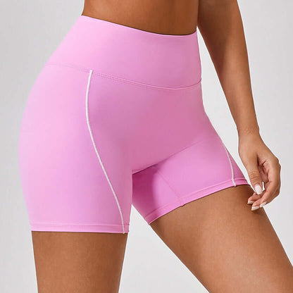 Pink high-waist fitness shorts for women with white seams, designed for comfort and performance. Ideal for gym, yoga, and summer workouts.