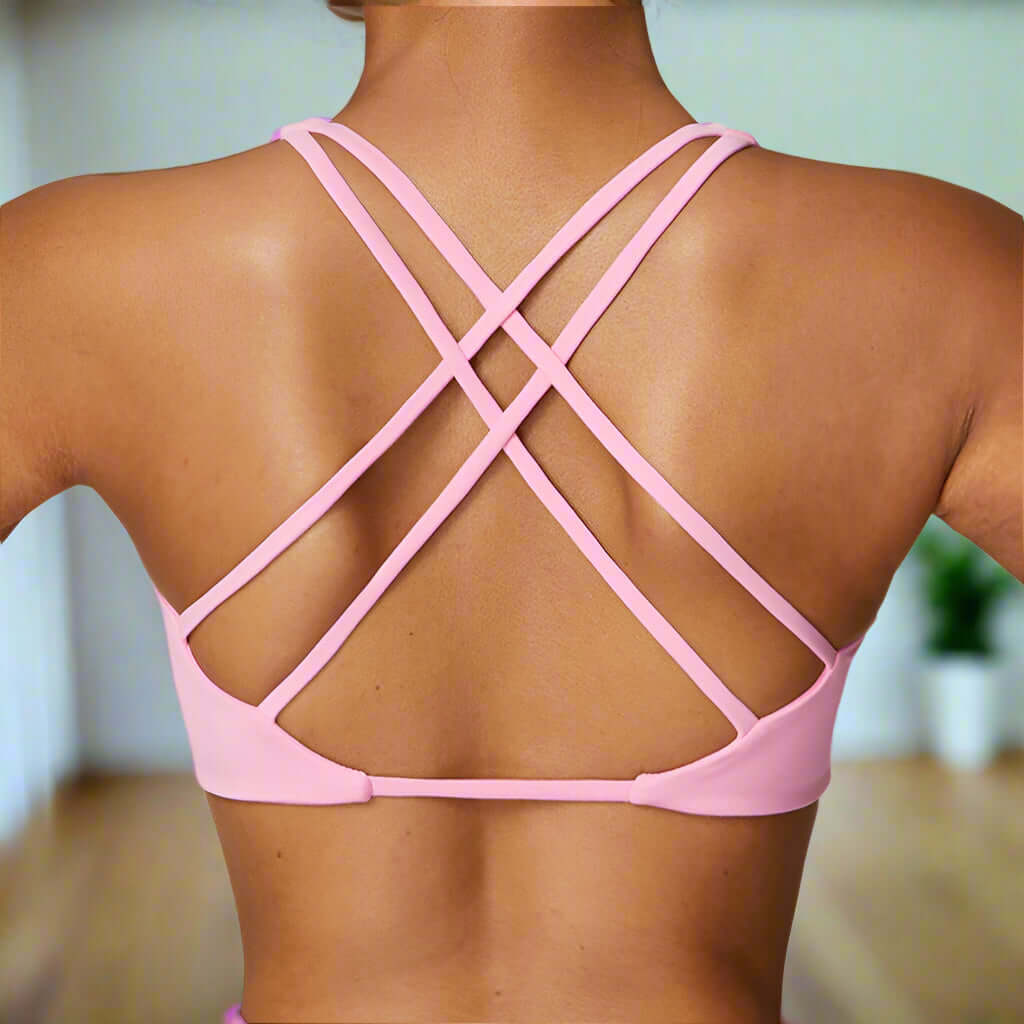 Back view of quick-dry pink sports bra with cross-back straps, ideal for gym workouts and yoga, breathable and wireless design.