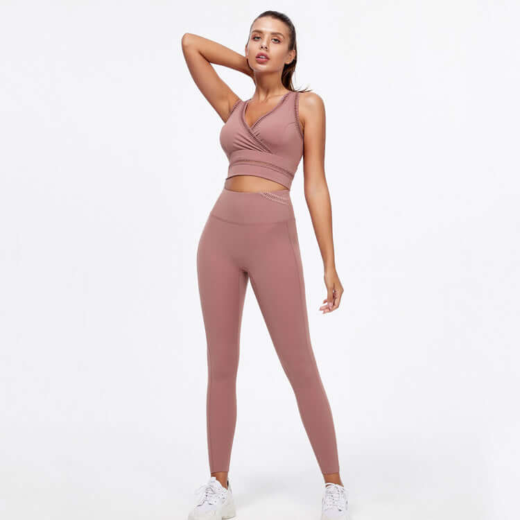 Woman wearing hip-lifting peach yoga fitness suit with sleeveless top and high-waisted leggings, ideal for gym and workout sessions.