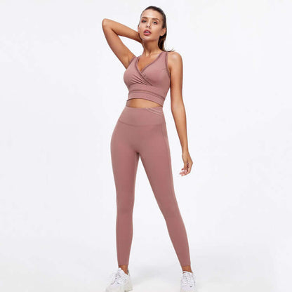 Woman wearing hip-lifting peach yoga fitness suit with sleeveless top and high-waisted leggings, ideal for gym and workout sessions.