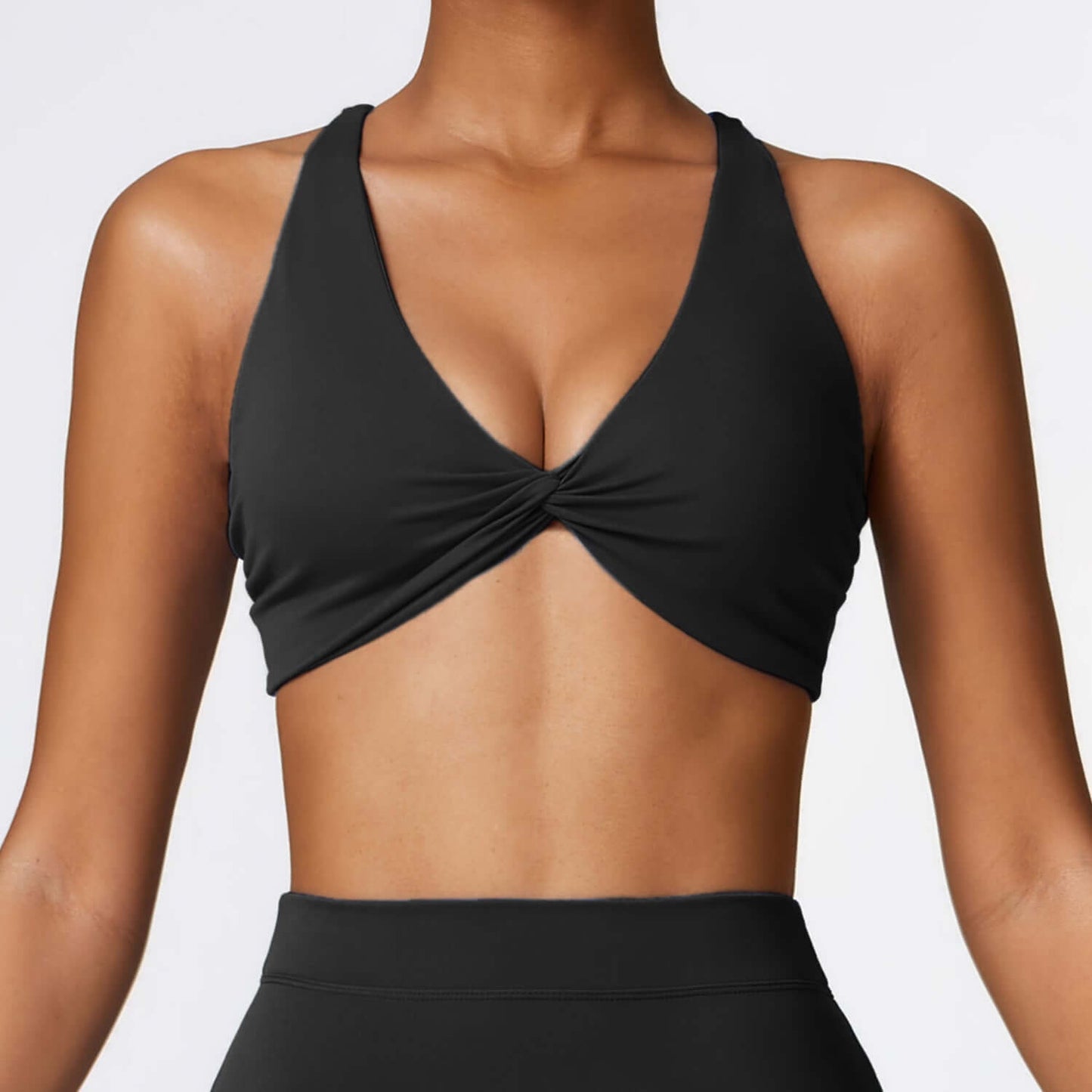 Woman wearing a black quick-dry sport bra with cross-back straps, ideal for yoga and workouts, in breathable fabric.
