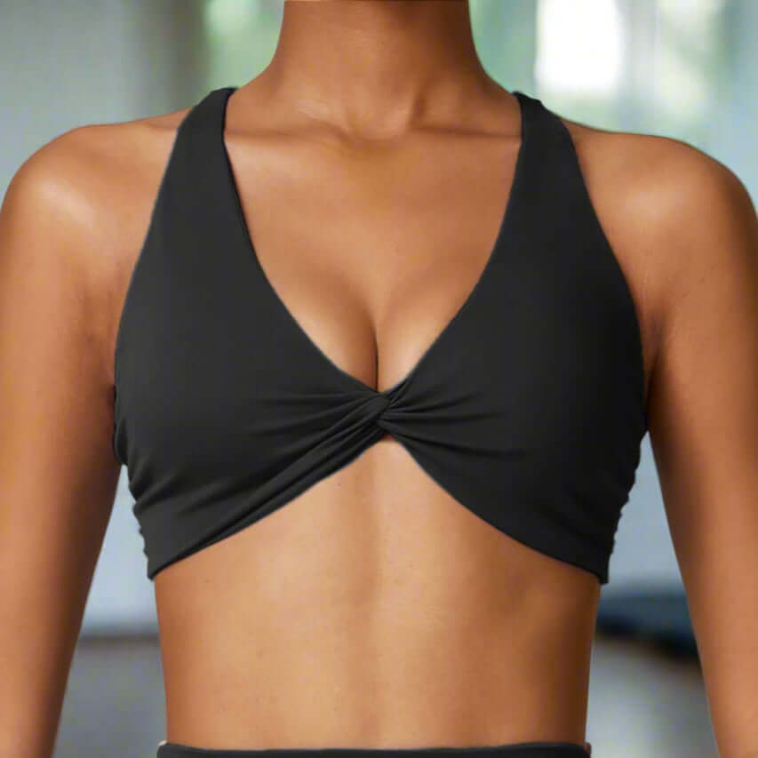 Woman wearing a premium black quick-dry sports bra with cross-back straps, ideal for workouts like yoga and running.