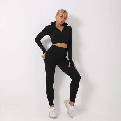 Woman wearing a black seamless leggings, crop top, and bra set, showcasing activewear fashion in a minimalist setting.