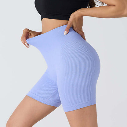 Woman wearing seamless stretch shorts in blue, showcasing flexible fit and breathable nylon fabric, ideal for fitness and casual wear.