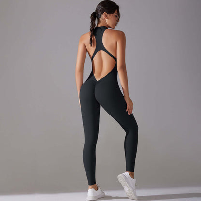 Woman wearing a black seamless workout jumpsuit with open back design, showcasing sleek and stylish fitness apparel suitable for gym or yoga.