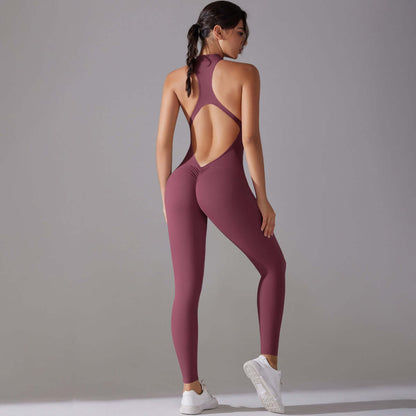 Back view of a woman wearing a seamless workout jumpsuit in burgundy, showcasing its open back design and sleek fit, ideal for fitness.