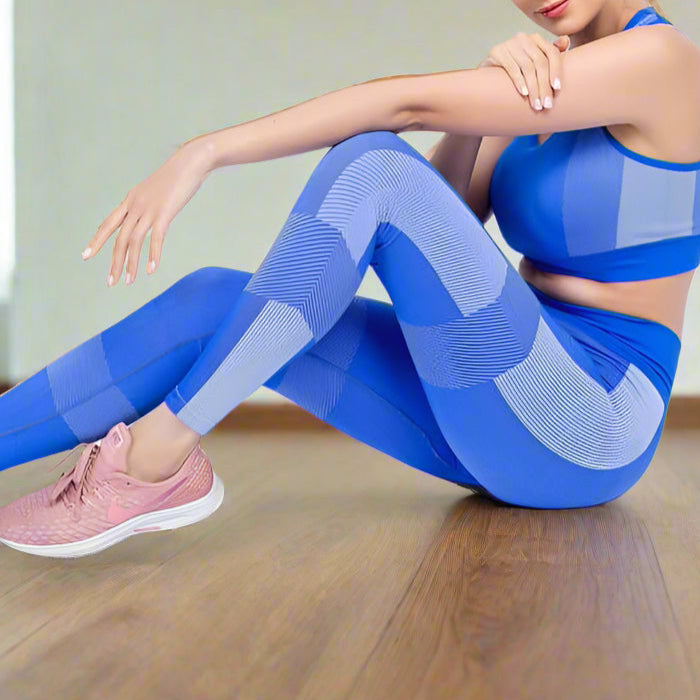 Woman wearing a blue seamless yoga set, seated on floor, showcasing sporty and breathable design for gym and yoga activities.
