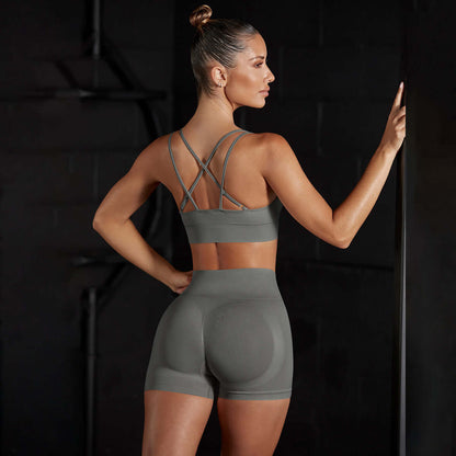 Woman in seamless stretch sports set for yoga and training, featuring a breathable cotton blend, sleeveless design, in solid color.