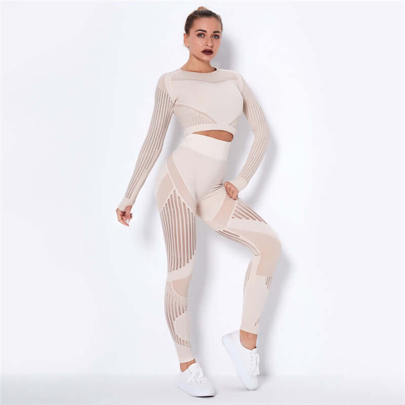 Woman wearing a stylish beige striped fitness set with long sleeves and leggings, posing confidently in athletic shoes.