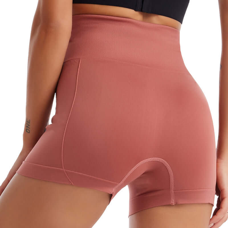 Back view of a woman wearing tight fit training leggings in pink, showcasing stretchy, seamless fabric for comfortable, women's activewear.