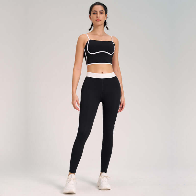 Woman wearing ultra-soft yoga outfit, 2-piece set, with black leggings and cropped top, standing in a neutral pose.