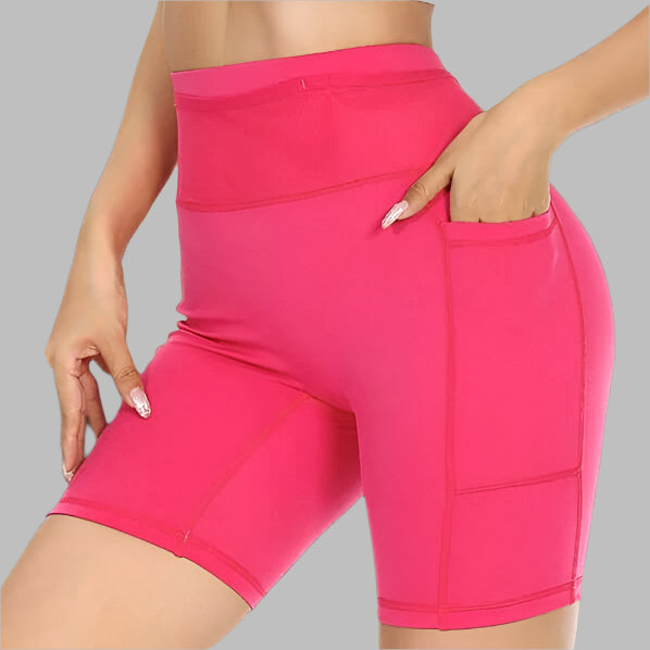 Women's compression shorts in vibrant pink with side pockets, designed for comfort and style.