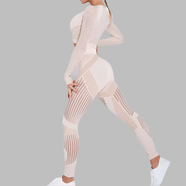 Woman wearing a beige striped fitness set with long sleeves and matching leggings, showcasing stylish and functional workout wear.