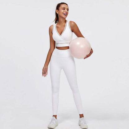Woman wearing white hip-lifting peach trousers fitness suit with exercise ball, showcasing activewear for yoga or gym.